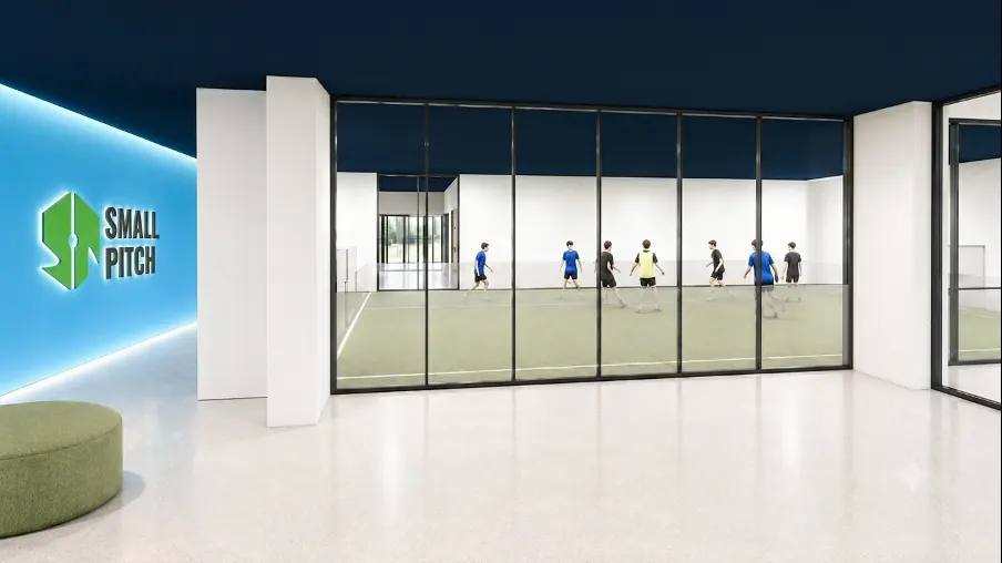 Interiør fra Smallpitch på Skullerud – lounge mot indoor-bane med spill i gang